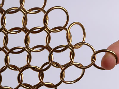 The picture shows a piece of brass coated chain braided ring mesh with one finger pulls.