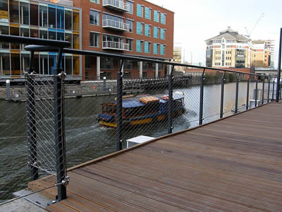 There is a stainless steel balustrade between river and bridge.