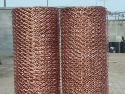 Two copper hexagonal wire mesh rolls are placed on the ground.