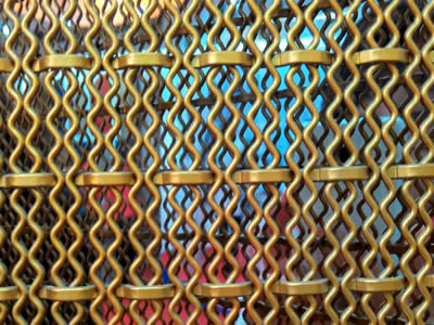 A decorative mesh which wraps are roll wires with patterns and wefts are thin and flat.