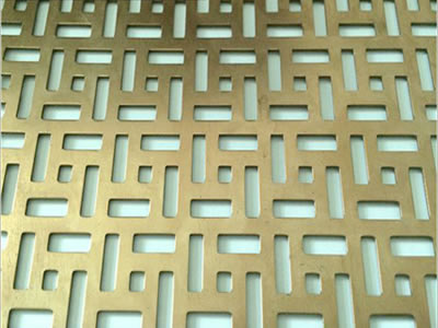 The picture shows a piece of five rectangles brass perforated mesh.