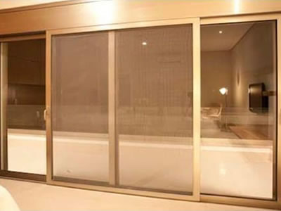 A brass insect screen inserted sliding door in a bedroom.