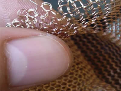 One hand takes the knitted wire mesh to make people see the detail clearly.