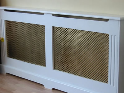 The picture shows a white cabinet with two brass perforated mesh screen.