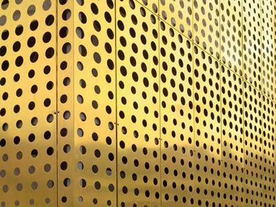 The picture shows brass perforated mesh facade with different sizes round.