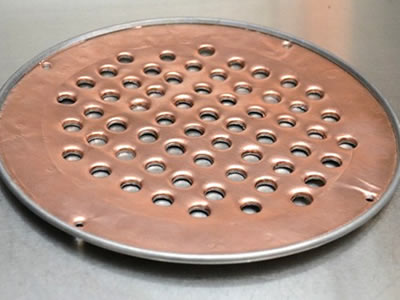 The picture shows a round copper perforated mesh with aluminum edge.