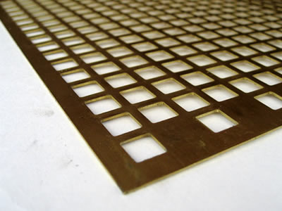 The picture shows a piece of square brass perforated mesh.