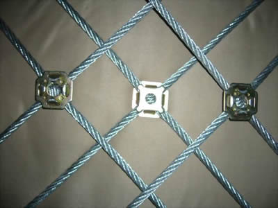 A piece of stainless steel square cable mesh with clamps on the grey background.