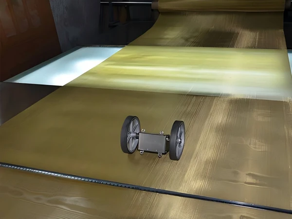 Woven brass wire mesh screen rolls, tape measure, and measuring device neatly placed on the testing platform