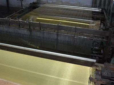 Woven brass wire mesh screen is being woven